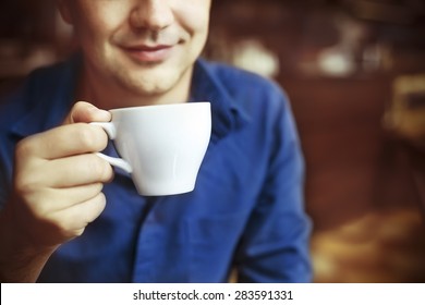 Man drinking white tea in white china tea cup in cafe - Powered by Shutterstock