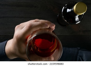 Man drinks alcohol at the table. Top view.