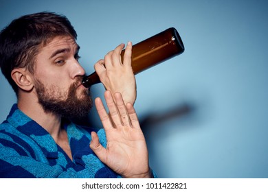 man drinks beer on a blue background                              