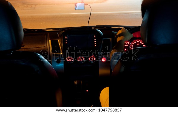 Man drive car stop\
on side road prepare turn on the road at night in front with motion\
of light speed from other car on the road.Center of car on roof\
with Camera Recorder.
