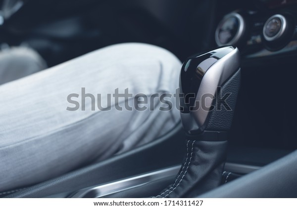 Man driver with automatic\
gear stick inside new modern sport car, driving on the road, close\
up