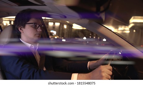 Man Driver In Black Suit And Eyeglasses Holding The Wheel. Middle Shot Of Driver At Night, Businessman In Car Driving At Night, Middle Shot