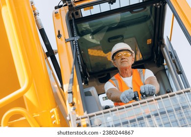 Man driver builder operate crane or excavator at construction site with sun light. Portrait Industry worker.