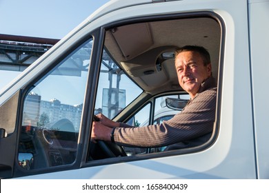 A Man Driver Is Sitting In The Cab Of A Modern Truck.