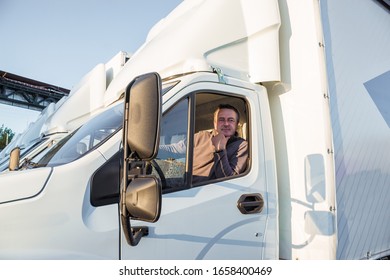 A Man Driver Is Sitting In The Cab Of A Modern Truck.