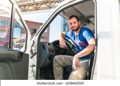 A Man Driver Is Sitting In The Cab Of A Modern Truck.