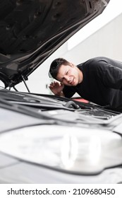 Man Driver Stands The Car With The Hood Open And Checks The Sound Of The Engine. Professional Mechanic Guy Checks The Car And Listens