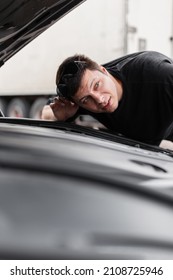 Man Driver Stands Near The Car With The Hood Open And Listens To The Sound Of The Engine. Buyer Checks Out The Car 