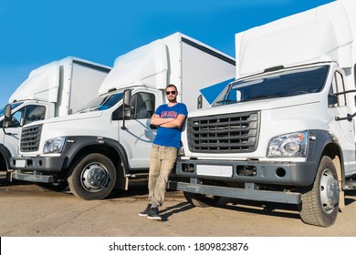 A man driver stands near the truck;