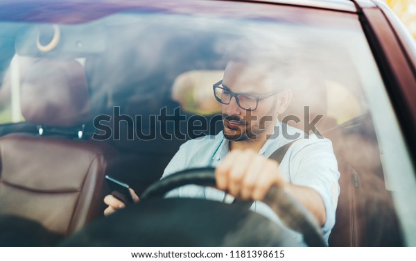 Man driver using\
smart phone in car modern