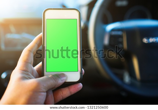 Man driver\
using smart phone in car, green\
screen.