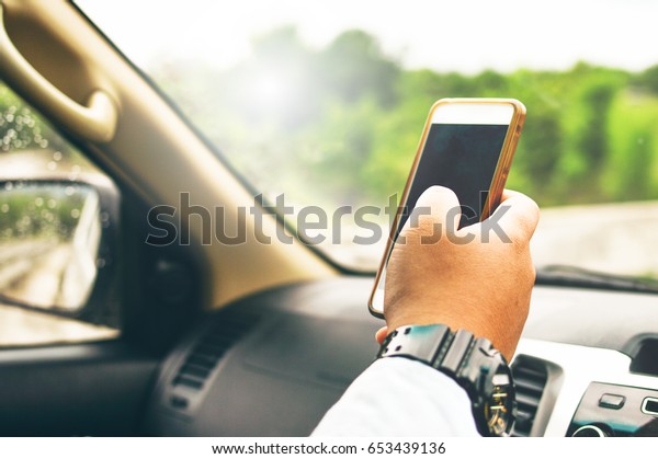 Man driver using smart\
phone in car