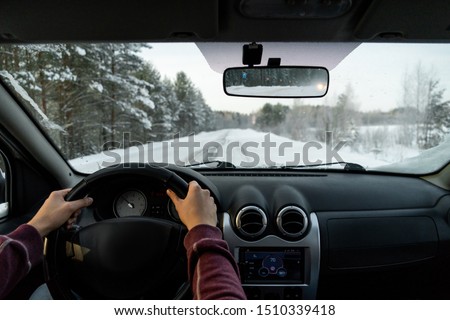 A man drives a car on a winter road.