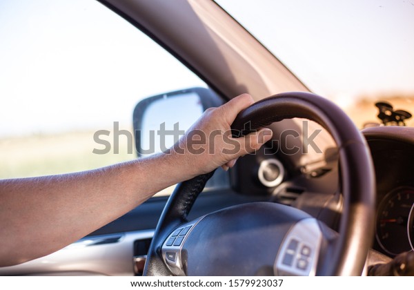 a man\
drives a car and turns the steering\
wheel