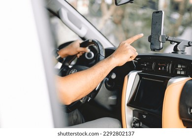 A man drives a car using a GPS navigation system on his mobile phone while driving, to find his destination. Transportation with technology concept. - Powered by Shutterstock