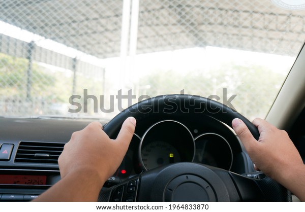 Man driving with both hands on steering\
wheel selective focus. safety driving\
concept