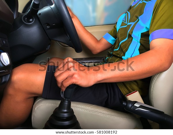 Man driving a car and
change gears.