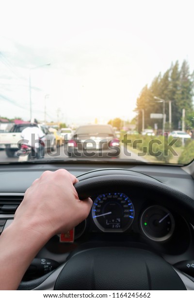 Man\
driving a car with a dirty front glass after a long drive on a\
highway with other vehicles blurred in front of\
him