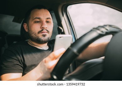 A Man Driving A Car Distracted By A Smartphone Creating An Emergency