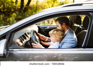 Man Driving A Car With Little Son.