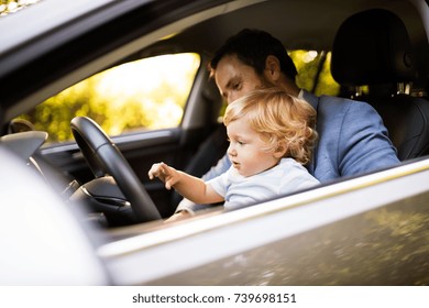 Man Driving A Car With Little Son.