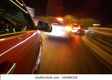 A Man Driving A Car At Night On A Straight Road. 