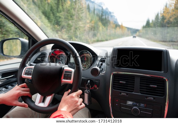 Man driving a car on the highway in autumn forest at\
national park