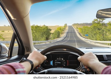 Man driving car on sunny morning, first-person view