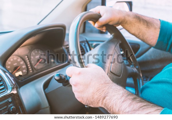 Man driving a car. Person drives a\
right-hand drive car in England, Japan or\
India.