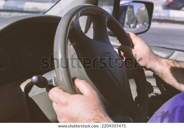 Man driving a car. Person drives a\
right-hand drive car in England, Japan or\
India.