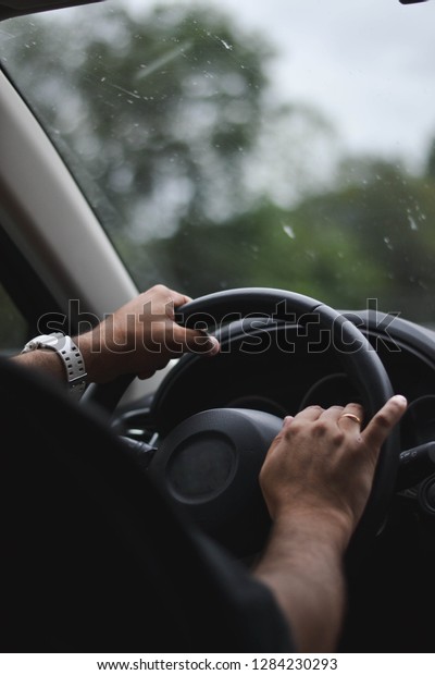 A man driving a car in a\
rainy day