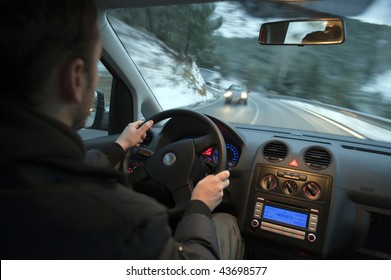 Man Driving Car In Snowed Mountain Road.