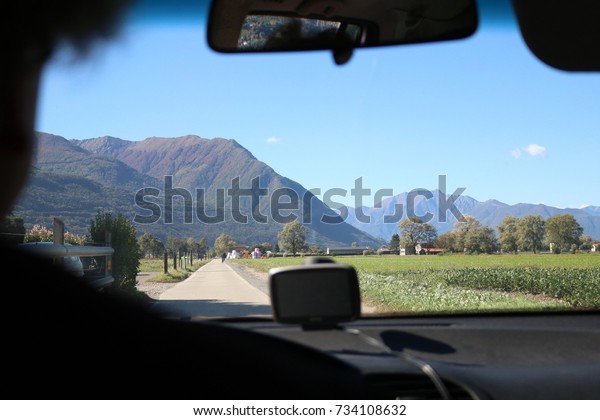 Man driving a car, street landscape\
background switzerland