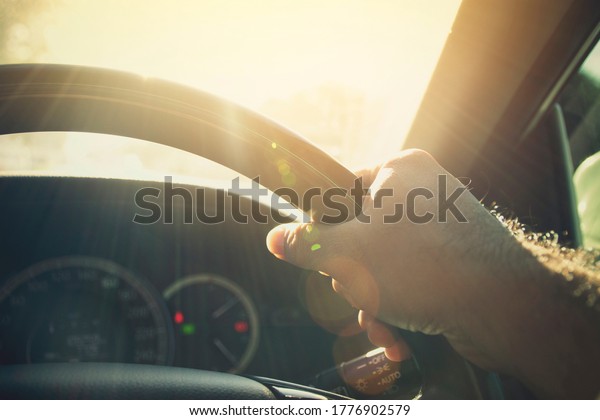 A man driving car in\
sunlight weather