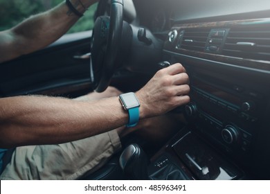 Man Driving A Car And Tuning Radio, Smart Watch On The Hand