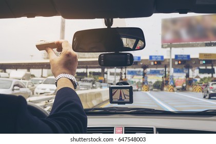 Man driving car using navigator and holding electronic toll collection system device - Shutterstock ID 647548003