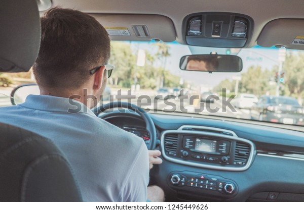 Man driving a car. View\
from the back