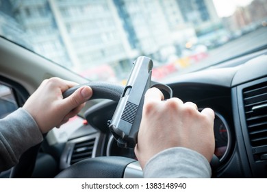 man driving a car with a weapon in his hand. the criminal steals the car. criminal district of the city - Shutterstock ID 1383148940