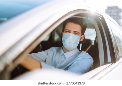 Man driving a car wearing on a medical mask during an epidemic, a driver- taxi in a mask. Covid-2019.