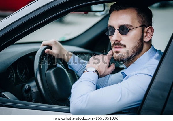 サングラスをかけた自信たっぷりの車を運転する男性 の写真素材 今すぐ編集