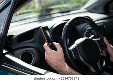 Man driving a car while using a smartphone, representing the danger of distracted driving and lack of attention on the road.