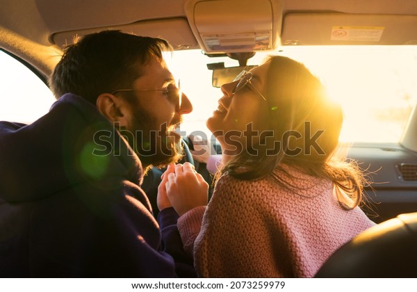 Man Driving Car\
with Woman Sitting on Passenger Seat. Lovers traveling holiday\
vacation road trip. Inside car together driving. Freedom love\
lifestyle. Romantic sunset\
journey