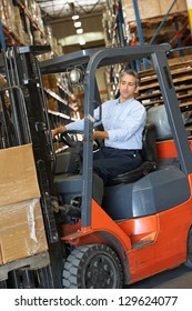 Man Driving Fork Lift Truck In Warehouse