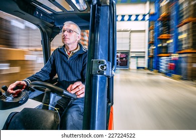 man driving a forklift through a warehouse in a factory