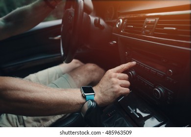 Man Driving His Car And Tuning Radio, Smart Watch On The Hand