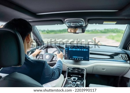 A man driving inside of electric car front view of the road. Electric car. EV Car. EV vehicle.