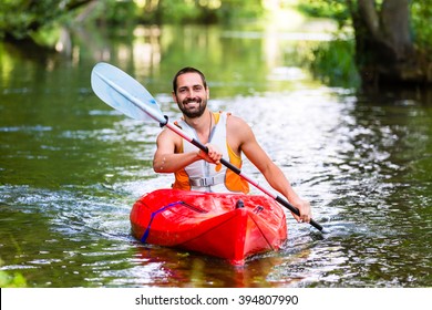 Man Driving With Kayak On Forest River