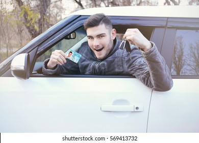Man with driving license and key in car