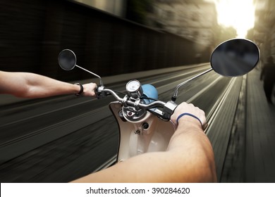 Man Driving On Scooter At Old Streets In City