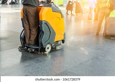 Man Driving Professional Floor Cleaning Machine At Airport Or Railway Station.  Floor Care And Cleaning Service Agency